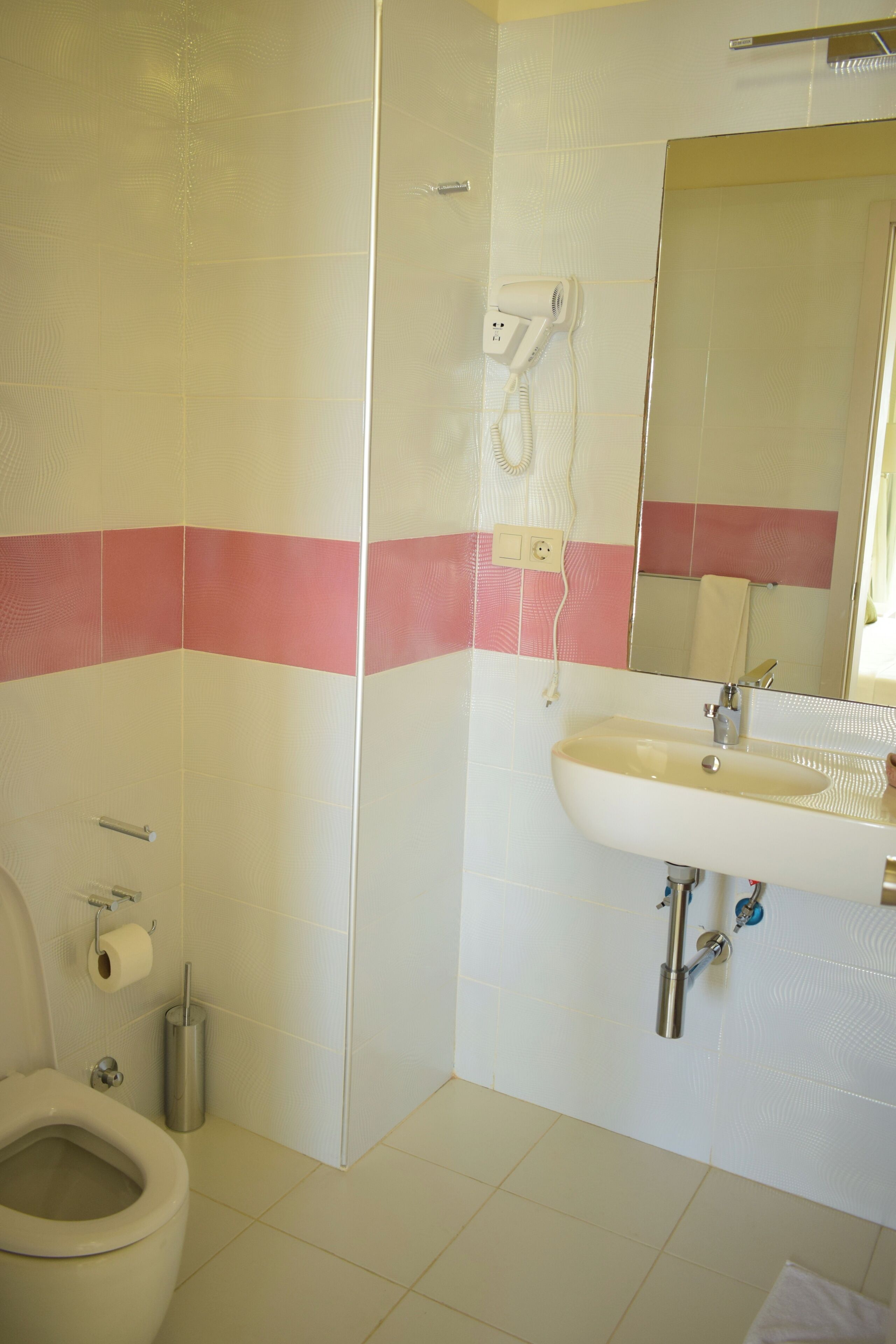 Un baño con inodoro, lavamanos y ducha.
