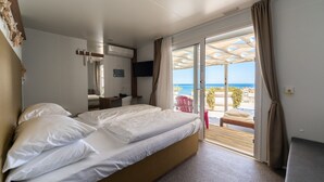 Una habitación de hotel con cama, escritorio, silla y vista a la playa.