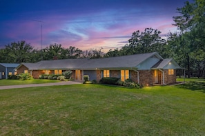 A two-story house with a brick exterior, a covered porch, and a well-maintained lawn.