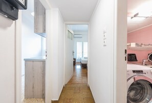 Enter a cozy bedroom with a comfortable bed, a bathroom with a toilet and sink, and a convenient washing machine.