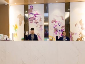 A reception desk with a marble top and a decorative wall with abstract floral patterns. - Lavande Hotels Guangzhou North Railway Station (Guangzhou)