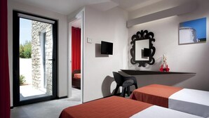 Een hotelkamer met twee bedden, een bureau, een televisie en een grote spiegel.