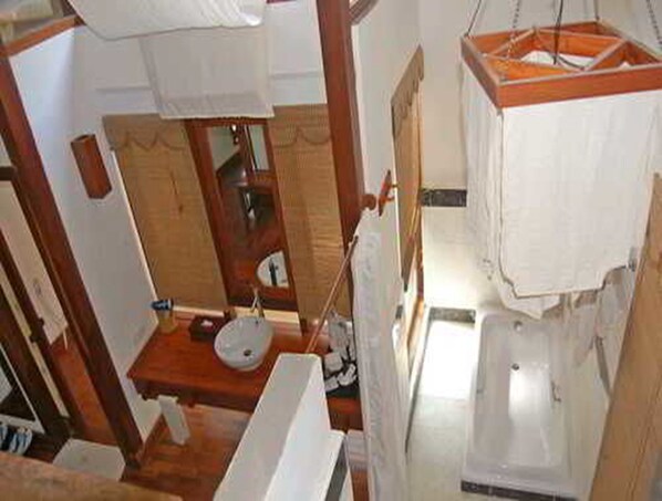 Un baño pequeño con un tocador de madera, un lavabo y una bañera.