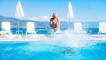 Relax by the serene pool surrounded by comfortable sun loungers and shaded umbrellas.