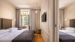Ein Hotelzimmer mit zwei Betten, einem Fernseher und Blick ins Freie.