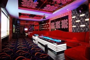 Una habitación con sofá rojo, zona de bar y paredes con diseño.