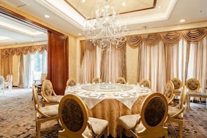 A formal dining room with a round table, chairs, and a chandelier. - Jiangyou International Grand Hotel (Jiangyou)