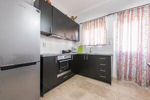 Een koelkast, een oven, een kookplaat, een koffiezetapparaat/waterkoker