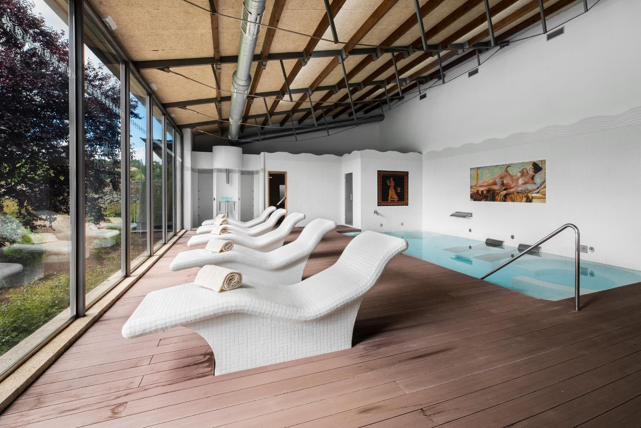 Zona de spa amb terrassa de fusta, una piscina i vistes a l'exterior.