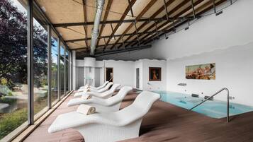 Zona de spa amb terrassa de fusta, una piscina i vistes a l'exterior.