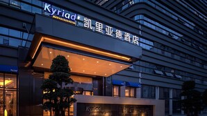 A hotel with a modern facade, signage in multiple languages, and a well-maintained garden area. - Kyriad Hotel Chengdu Wuhou NEW City (Chengdu)