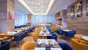 A spacious hotel dining area with multiple tables and chairs, a long counter, and a chandelier. - Kyriad Hotel Chengdu Wuhou NEW City (Chengdu)