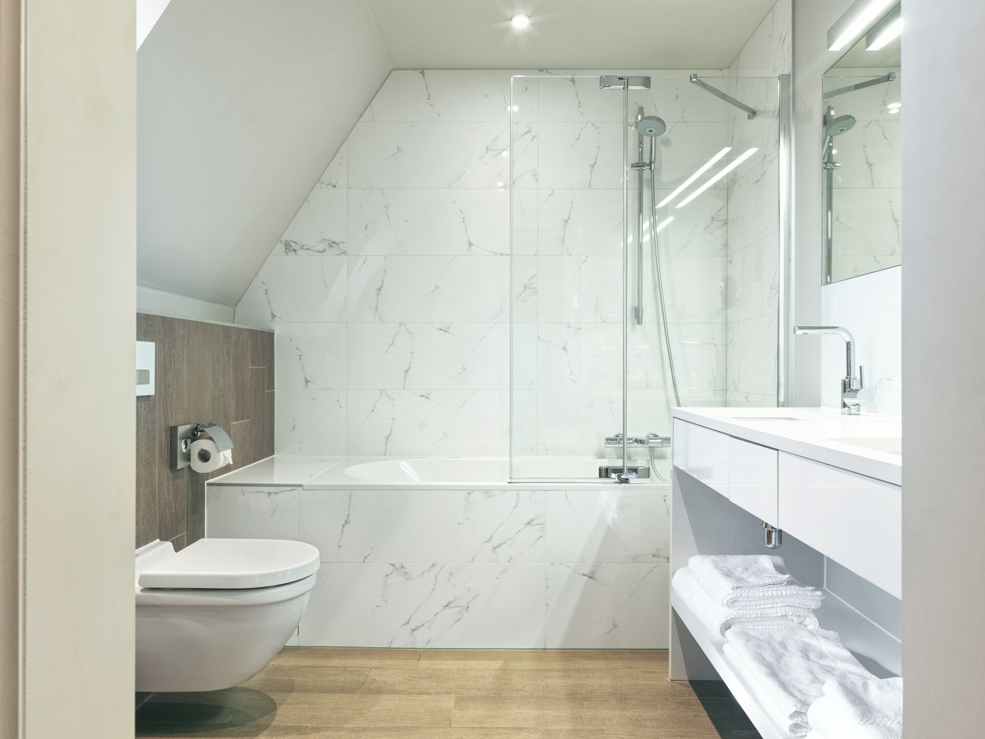 A modern bathroom with a shower, toilet, and vanity.