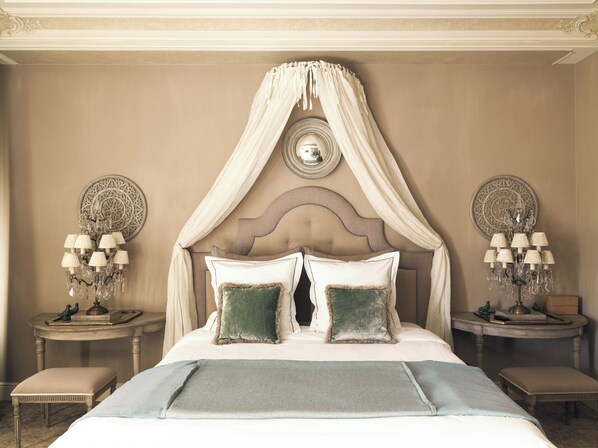 A bedroom with a canopy bed, two bedside tables with lamps, and decorative wall plates. - Kasteel van Ordingen (Sint-Truiden)