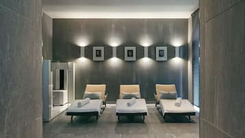 Relax in comfort with three plush chairs, a wall of framed artwork, and a large window with blinds.
