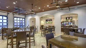 A spacious indoor dining area with multiple tables and chairs, ceiling fans, and large windows. - 5BD Windsor Westside Private Pool (WW 8920) (Kissimmee)
