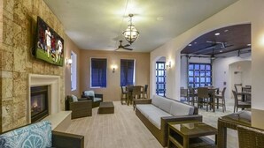 A spacious living area with a fireplace, comfortable seating, and a television mounted on the wall. - 5BD Windsor Westside Private Pool (WW 8920) (Kissimmee)