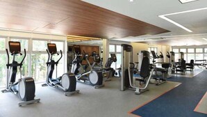 A gym with multiple exercise machines, large windows, and a modern ceiling design. - Modern Apartment in Scenic Valley Phu My Hung D7 (Ho Chi Minh City)