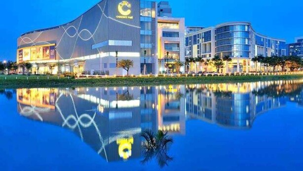 A modern hotel with a large central building and a reflective pool in front. - Modern Apartment in Scenic Valley Phu My Hung D7 (Ho Chi Minh City)