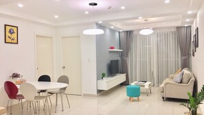 A modern living room with a dining area, a TV, and a sofa. - Modern Apartment in Scenic Valley Phu My Hung D7 (Ho Chi Minh City)