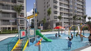 A children's water play area with slides and water features, surrounded by residential buildings. - Modern Apartment in Scenic Valley Phu My Hung D7 (Ho Chi Minh City)