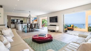 En moderne stue med sofa, sofabord og spiseplads.