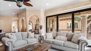 A spacious living room with two sofas, a coffee table, and a ceiling fan.