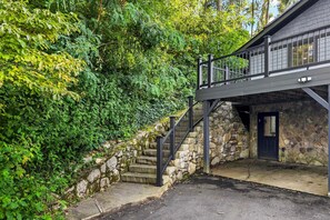 A stone staircase leading to a building with a dark door, surrounded by lush greenery. - Blue Ridge Bliss | Mountain Home with Hot Tub & Stunning Views! (Weaverville)