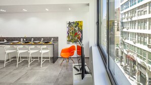 Eine moderne Küche mit Essbereich, einem großen Fenster und Blick auf die Stadt.