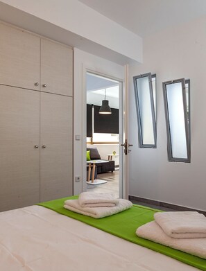 Un dormitorio con una cama, un tapete verde y un armario.