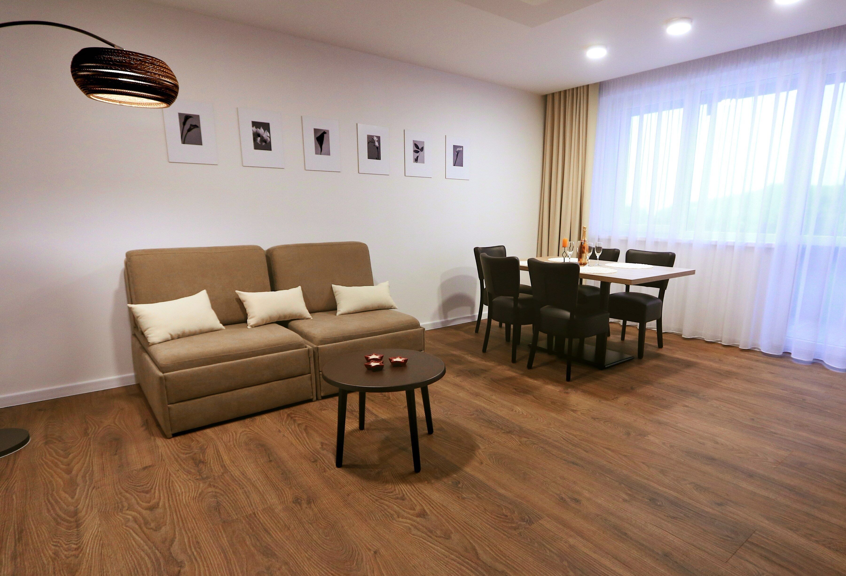Una sala de estar moderna con un sofá, una mesa de centro y un comedor con sillas y una mesa.
