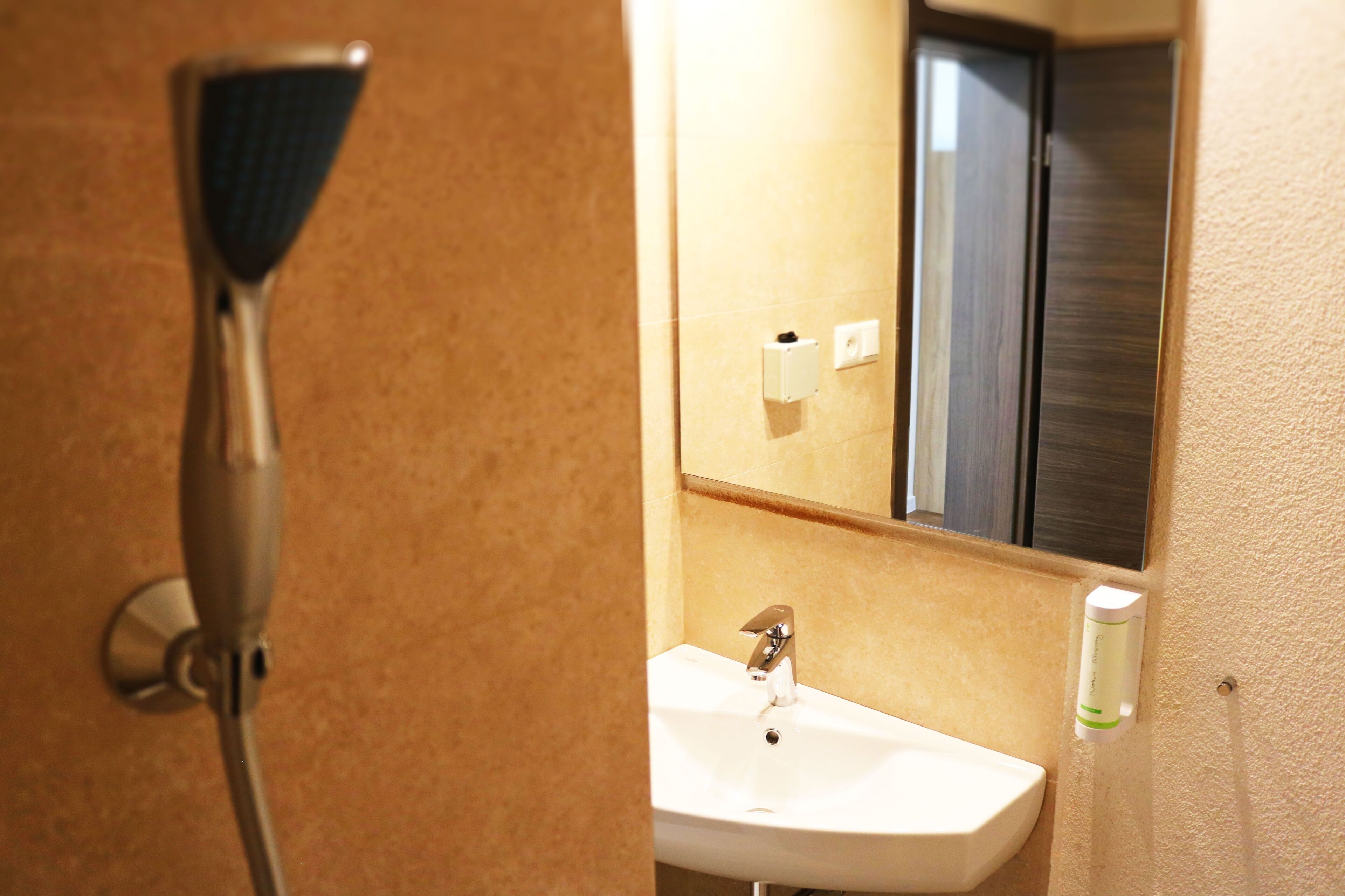 A bathroom with a shower, sink, and mirror.