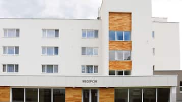 A modern building with a reception area, multiple windows, and a sign that reads "RECEPCIA".