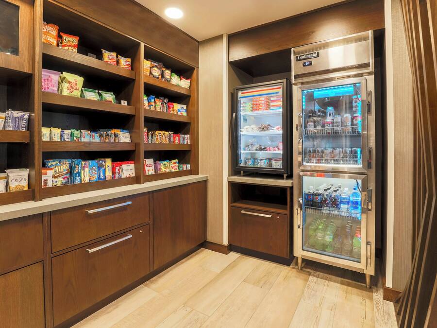 A kitchenette with wooden cabinets, a refrigerator, and a freezer.