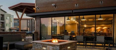 A modern building with a stone fire pit and outdoor seating.