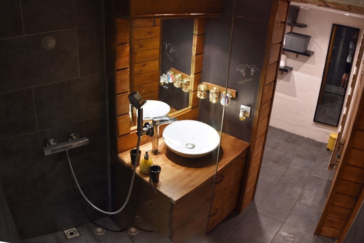 Une petite salle de bain avec un meuble-lavabo en bois, un lavabo rond et un miroir.