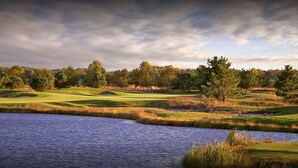 A golf course with a water body in the foreground and trees in the background. - 4-bedroom 4.5 bath Home in Bear Trap Golf Resort-- 3 minutes from Bethany Beach (Ocean View)