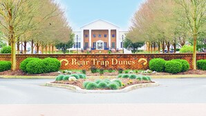 A building with a sign reading "Bear Trap Dunes." - 4-bedroom 4.5 bath Home in Bear Trap Golf Resort-- 3 minutes from Bethany Beach (Ocean View)