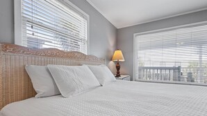 A neatly made bed with a quilted white cover, a wooden headboard with carved details, and a bedside lamp. - PRIVATE HOME, CLOSE TO THE BEACH, GREAT FOR FAMILIES, CONVENIENT TO EVERYTHING (Gulf Shores)