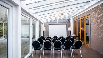 A conference room with a glass ceiling, a whiteboard, and a row of chairs.
