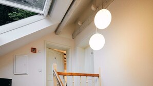 Una escalera con barandilla de madera y vista a una puerta en la parte superior.