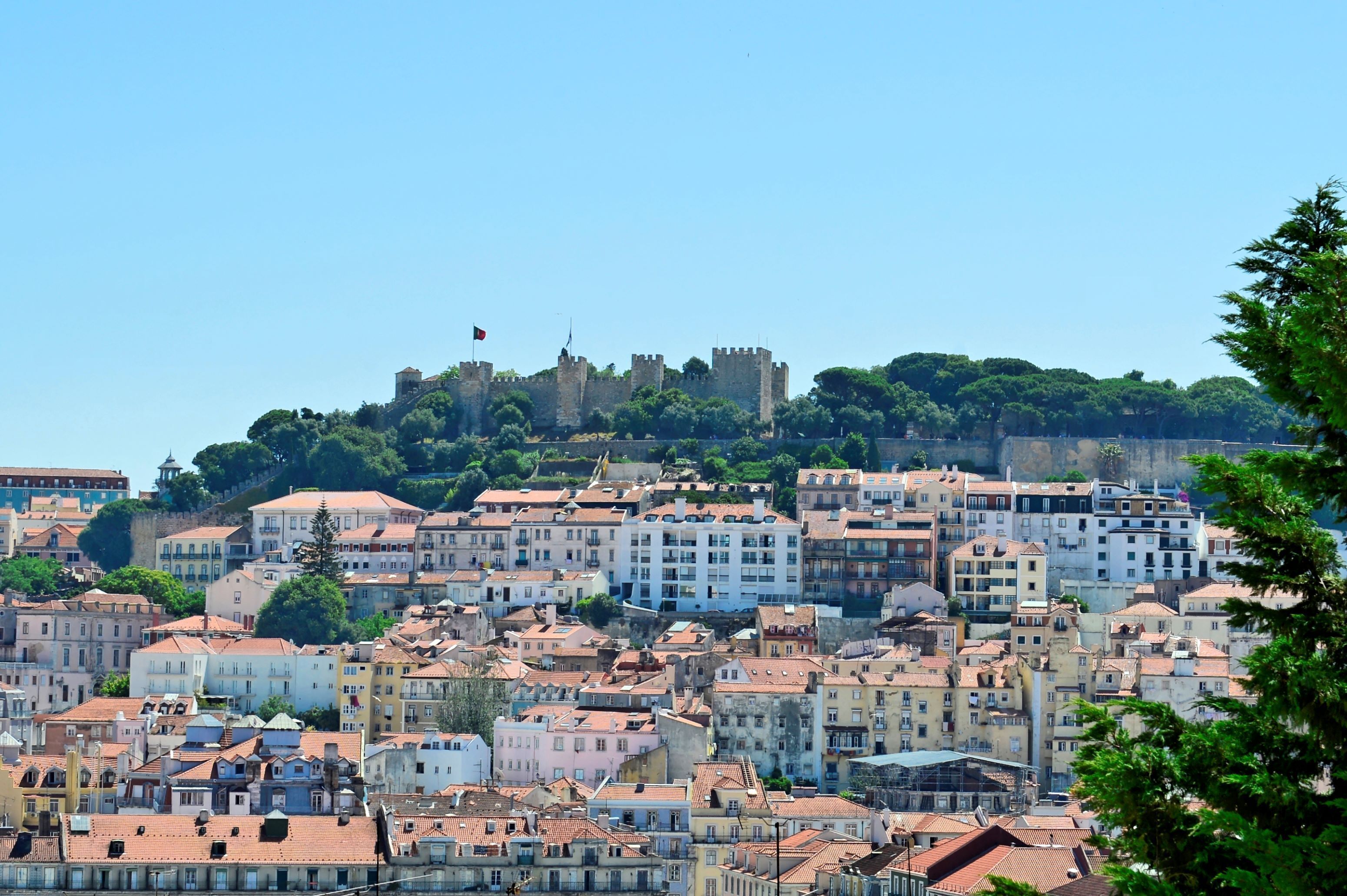 Un paisaje urbano con edificios históricos y un castillo en una colina.