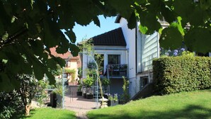 A residential building with a balcony, surrounded by greenery and a pathway. - Vacation apartment Haus am Jakobsweg (Fischbach bei Dahn)