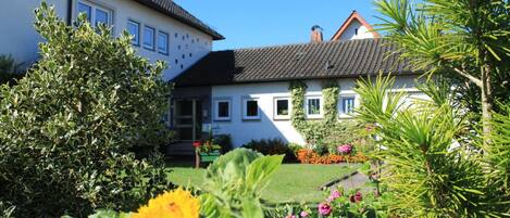 A two-story house with a garden in front.