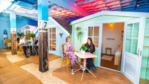 A cozy indoor setting with wooden floors, a table with chairs, and a door leading to another room. - Outside Inn (Amsterdam-Duivendrecht)