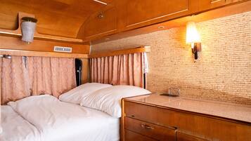 Une chambre à coucher avec un lit, des armoires en bois et un mur en briques.