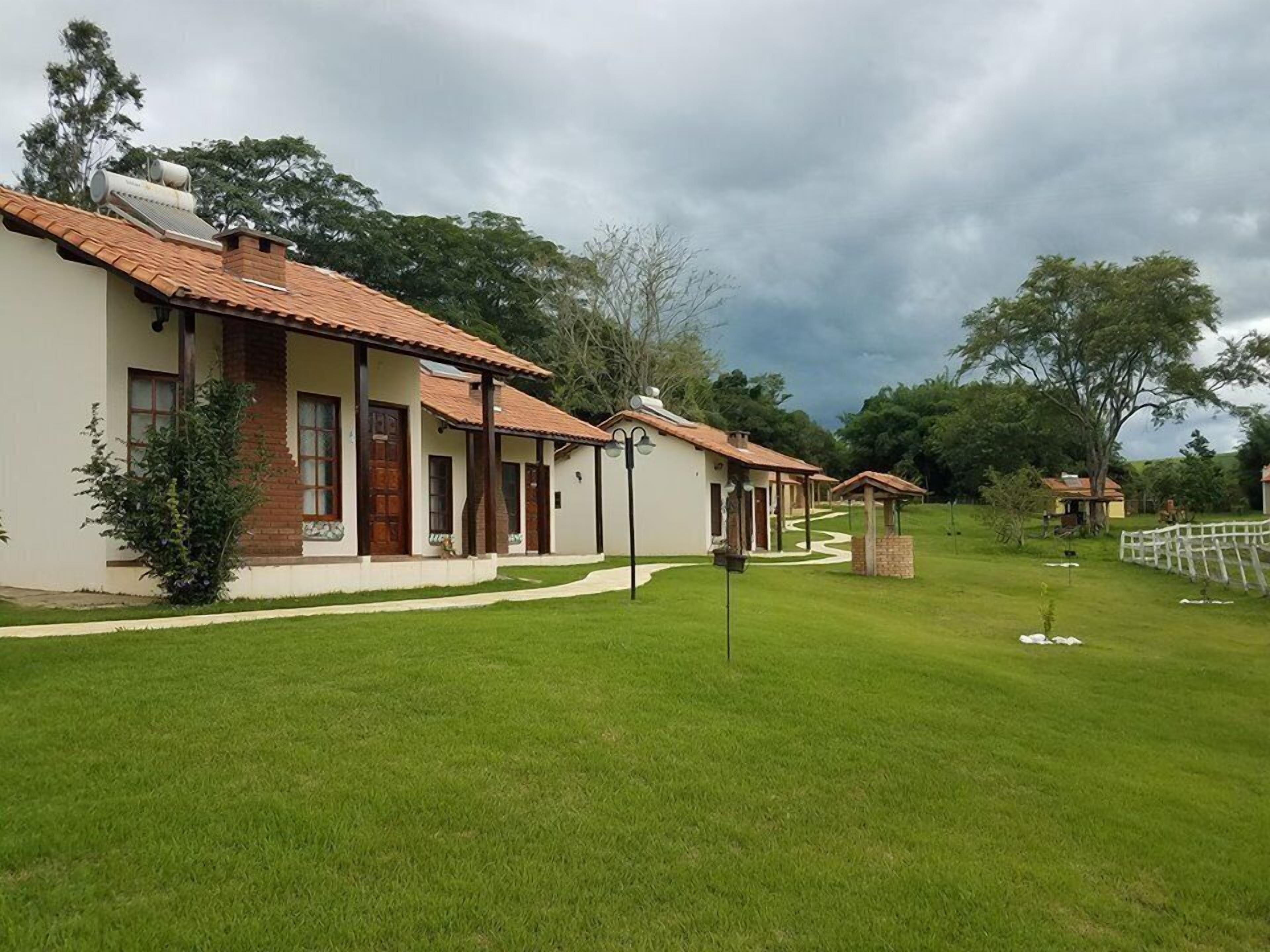 A row of single-story buildings with a consistent architectural style, featuring tiled roofs and a well-maintained lawn.