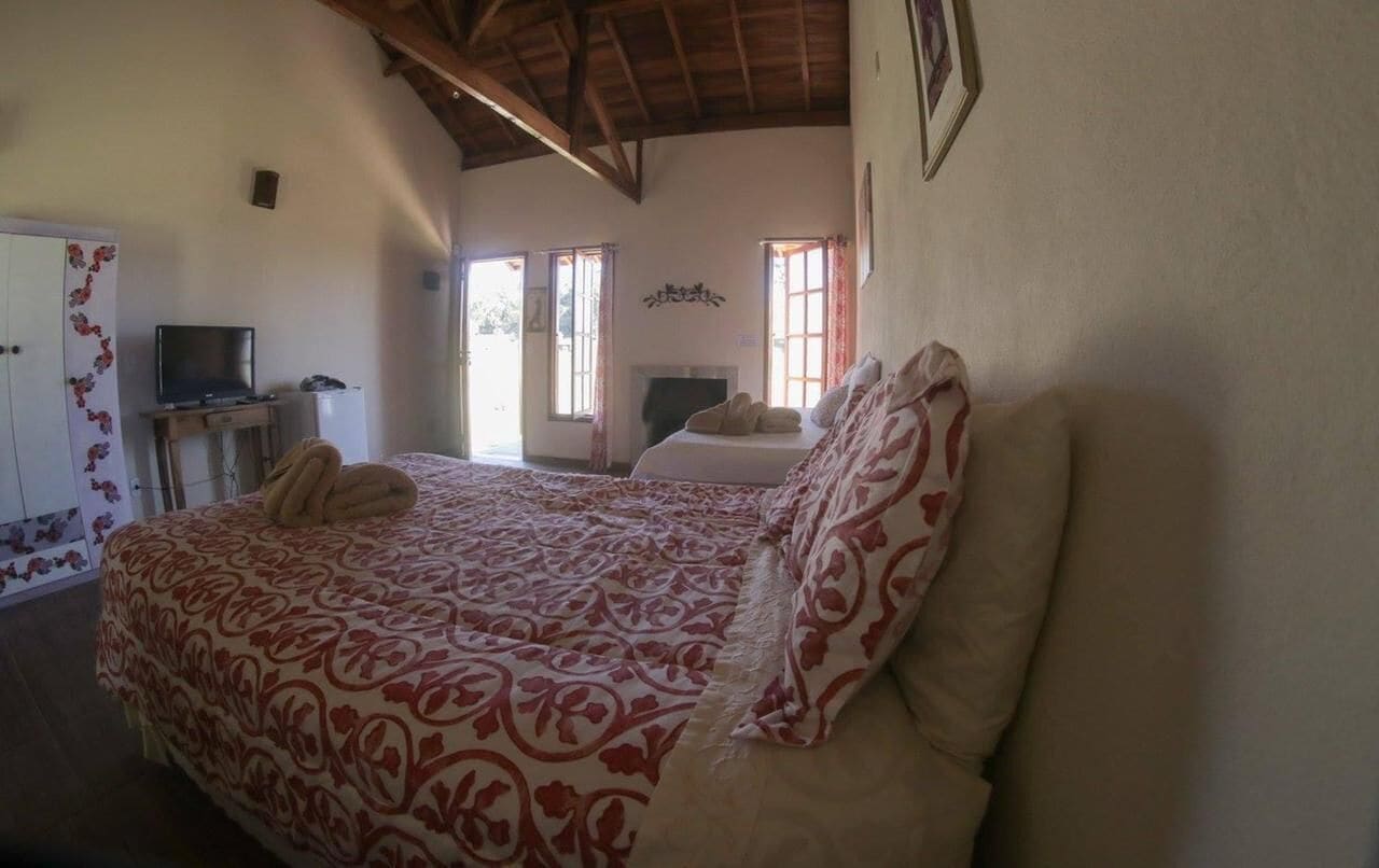 A bedroom with a bed, a television, and a desk.