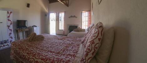 A bedroom with a bed, a television, and a desk.