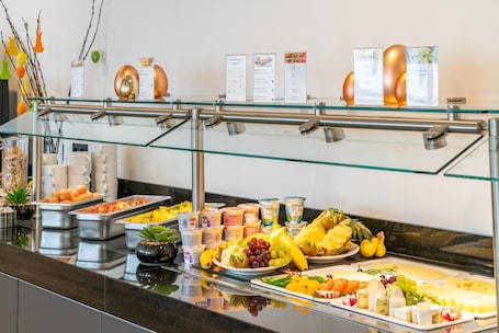 A buffet with various food items and a glass railing.